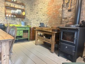 a kitchen with a wood stove and a table at Castle Street in Balnacart