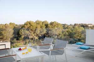 a patio with chairs and a table with a plate of fruit at Aparthotel Marina Drach in Porto Cristo