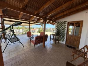 a living room with a porch with chairs and a ladder at Bratis House 2 in Vartholomio