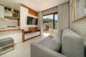 Sunrise Residence في بومبينهاس: غرفة معيشة مع أريكة وتلفزيون