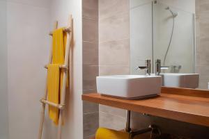Un baño con un lavabo blanco y un espejo. en Bungalow 8 - Caleta Campos, en Arrieta 20 fotos más