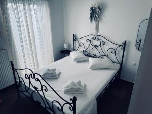 un letto bianco e nero con cuscini bianchi di Portolos Apartments - Filiatro a Vathi