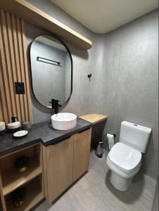 a bathroom with a toilet and a sink and a mirror at Pousada Ilha Canela in Palmas +20 photos