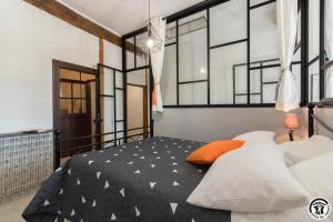 a bedroom with a black and white bed with windows at Escapade lauragaise in Saint-Félix-Lauragais