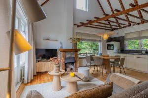 Una sala de estar con un sofá y una chimenea. en Strandbloem, en Hollum