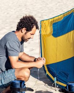 ein Mann sitzt mit einem Drachen am Strand in der Unterkunft Casa Maré Beach em Caetanos Ceará in Amontada