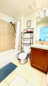 een badkamer met toilet, bad en wastafel bij Double room-wake up to stunning sunrises, unwind magical sunsets in Tacoma