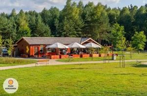 a building in the middle of a green field at Domek Park Korzonek in Korzonek
