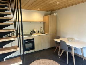 a kitchen and dining room with a table and stairs at 35 m2 duplex in a new 2025 chalet in Saint-Gervais-les-Bains