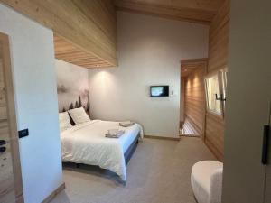 a bedroom with a bed and a tv on the wall at 35 m2 duplex in a new 2025 chalet in Saint-Gervais-les-Bains +9 photos