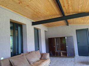 a couch in a living room with a wooden ceiling at Datucha's guesthouse in Ghebi