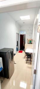 a living room with a table and a refrigerator at Naya Homestay Kuningan in Balong +1 photo