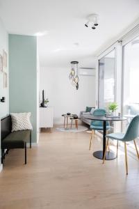 una sala de estar con una mesa y sillas en Stylish City Suite, Balcony, Augarten & Center, en Viena
