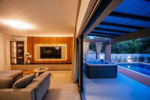 Una sala de estar con un sofá y una piscina. en Villa Relax Petrčane, en Petrčane