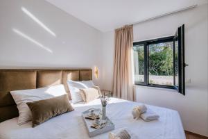 Un dormitorio con una cama con sábanas blancas y una ventana. en Villa Relax Petrčane, en Petrčane 51 fotos más