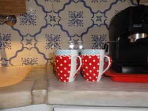 two cups sitting on a counter next to a toaster at Herdade do moinho in Santiago do Cacém