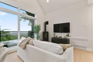 a living room with a white couch and a large window at Elska - SPA and Mountain in Saint Come