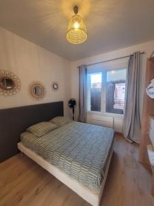a bedroom with a bed and a window at l'Horizon in Fos-sur-Mer