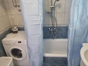 a bathroom with a shower and a washing machine at Amigo Apartment in Mostar +11 photos