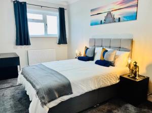 a bedroom with a large bed with blue curtains at Spacious 6 Bedroom House with Free Parking for Contractors and Business in Basildon +12 photos