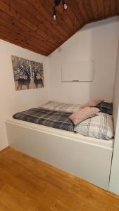 a bed in a white room with two pictures on the wall at Wochenend Ferienhaus mit tollen Ausblick in die Bucklige Welt in Kühbach