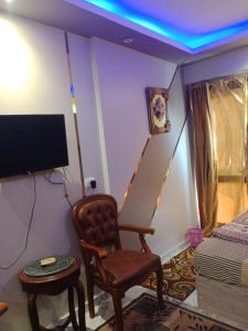 a living room with a chair and a tv at قريه بورتو جولف مارينا in El Alamein