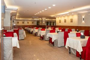 a dining room with white tables and red chairs at Al Manara Ewaa Hotel in Mecca