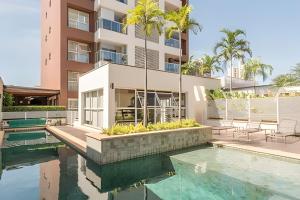 a swimming pool in front of a building at Moderno Apartamento no Cambuí in Campinas