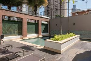 a patio with a swimming pool and a building at Moderno Apartamento no Cambuí in Campinas