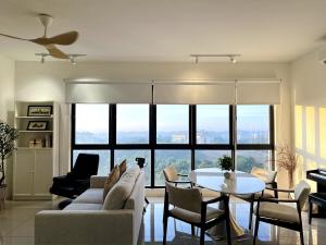 a living room with a couch and a table and chairs at NEW Designer Condo - Panoramic Forest View - Steps To IOI City Mall - Your Best Urban Retreat in Putrajaya