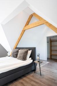 a bed in a room with a white ceiling at Compleet nieuw vakantiehuis Villa de Berken in Ede