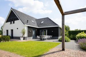 a white and black house with a patio at Compleet nieuw vakantiehuis Villa de Berken in Ede