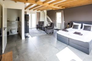 a bedroom with a large bed and a bathroom at Compleet nieuw vakantiehuis Villa de Berken in Ede