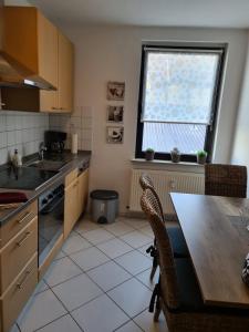 a kitchen with a table and a sink and a window at Übernachten im Herzen des Ruhrpotts in Bochum +5 photos