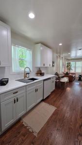 eine Küche mit weißen Schränken und ein Wohnzimmer in der Unterkunft Oak and Agave House - Downtown New Braunfels Retreat in New Braunfels