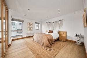 une chambre blanche avec un lit et une fenêtre dans l'établissement Harbour Heights - Escape Ordinary, à Portstewart