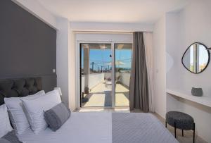 a bedroom with a bed and a view of a balcony at United Cretan Villas in Agia Marina Nea Kydonias