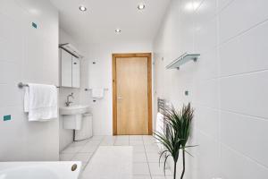 une salle de bain blanche avec une porte en bois et une plante dans l'établissement Harbour Heights - Escape Ordinary, à Portstewart 56 autres photos
