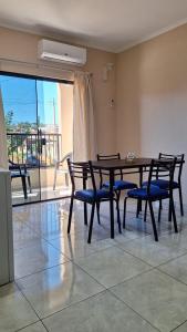 une salle à manger avec une table et des chaises et un balcon dans l'établissement Apart puesta del sol Iguazú, à Puerto Iguazú