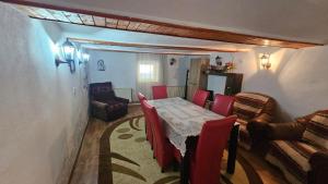 a dining room with a table and red chairs at Casa rustică in Ludoş