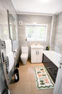 a bathroom with a toilet and a tub and a sink at Cliveden Garden Cottage sleeps 6 - With Hot Tub, Parking, in Taplow - next to Cliveden National Park in Maidenhead