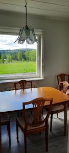 a dining room table with chairs and a window at Lilla Villa Svanö in Lunde