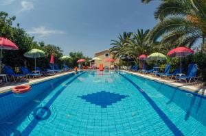 a large swimming pool with chairs and umbrellas at Villa Eleni Holidays Resort up to 18 guests in Karousádes