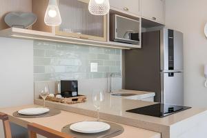 a kitchen with a table with two white plates on it at Aconchegante Studio no Cambuí in Campinas