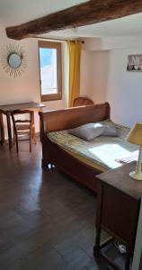 a bedroom with a bed and a table and a window at Chambres D'hôtes Le Bellevue - in Montbrun-les-Bains
