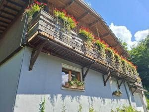 a building with a balcony with potted plants on it at Appartement du bois des Fugiers in Ugine