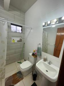 a white bathroom with a toilet and a sink at Comodo Dpto bien equipado cerca de Aeropuerto y COP Comité Olímpico Py in Luque +15 photos