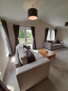 a living room with a couch and a table at Pullman Lodge in Glemsford