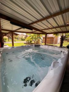 a jacuzzi hot tub with an umbrella at Maison spacieuse - Jacuzzi - Proche cœur historique in Sarlat-la-Canéda