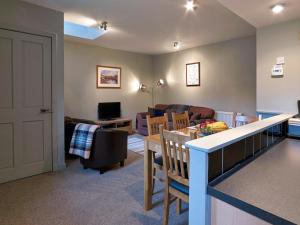 a living room with a kitchen and a living room with a table at Dunvegan Castle Laundry Cottage in Dunvegan